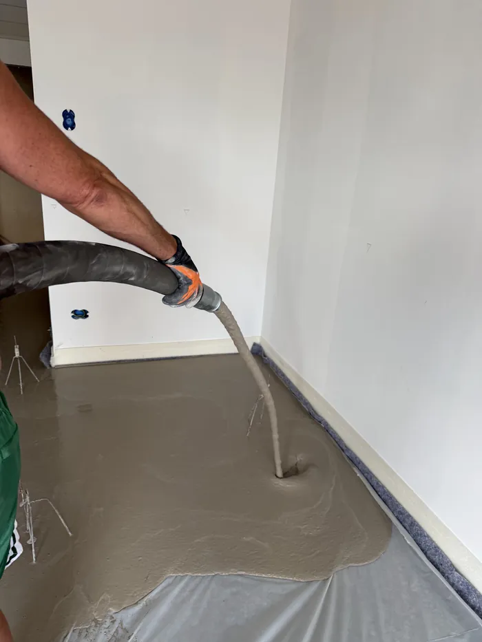 Autolivellante versato dal tubo della pompa: il materiale si distribuisce da solo sul piano